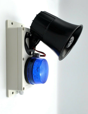 A wall-mounted wireless shed, garage alarm featuring a black siren and a blue strobe light on a white housing, photographed against a plain white background.