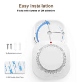 White ceiling-mounted smoke detector shown with its cover removed, plus included installation accessories: two screws, double-sided tape, and adhesive. Text at the top reads 'Easy Installation' and 'Fixed with screws or 3M adhesive.